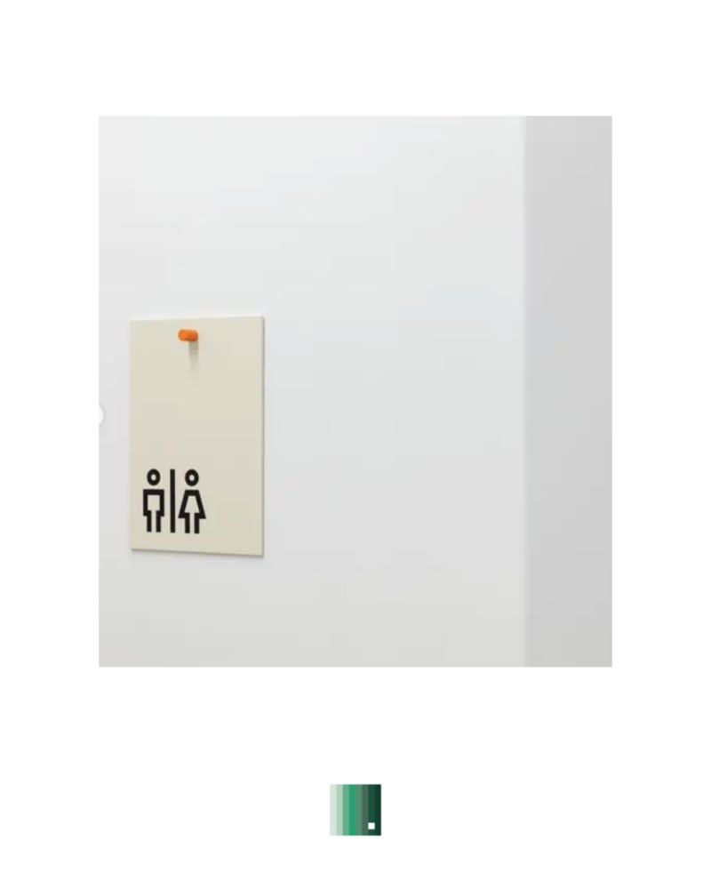 A restroom sign with male and female figure icons on a wall