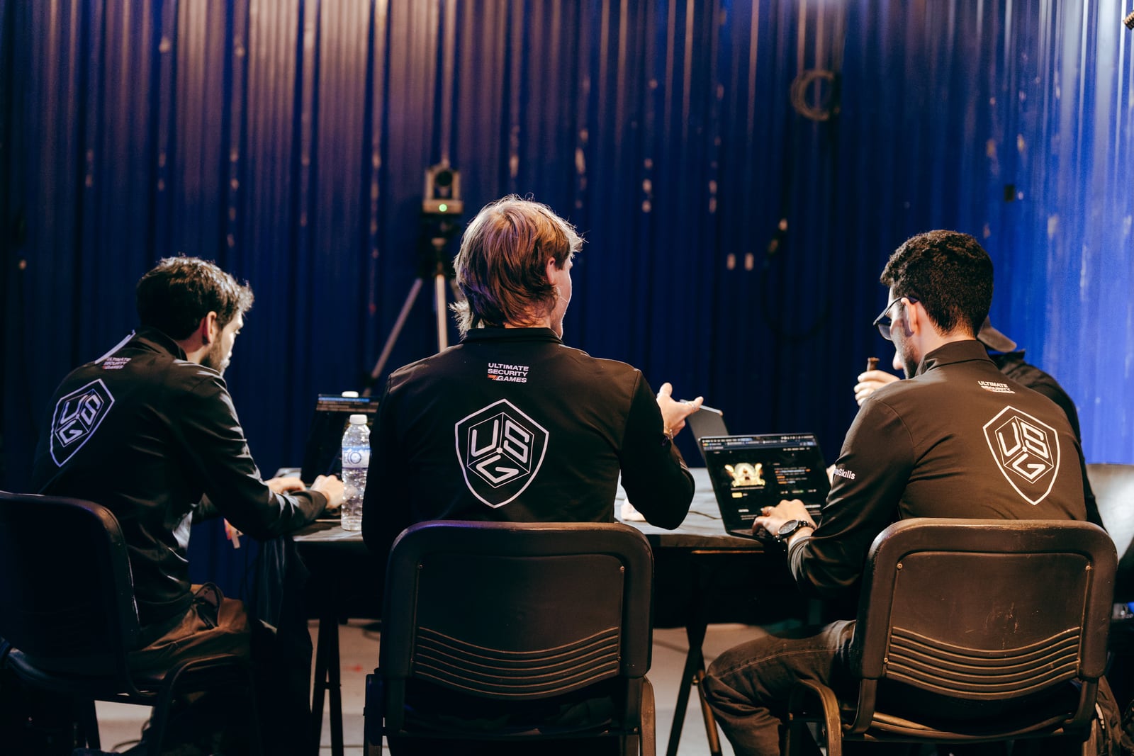 USG crew at the commentary desk in branded jerseys
